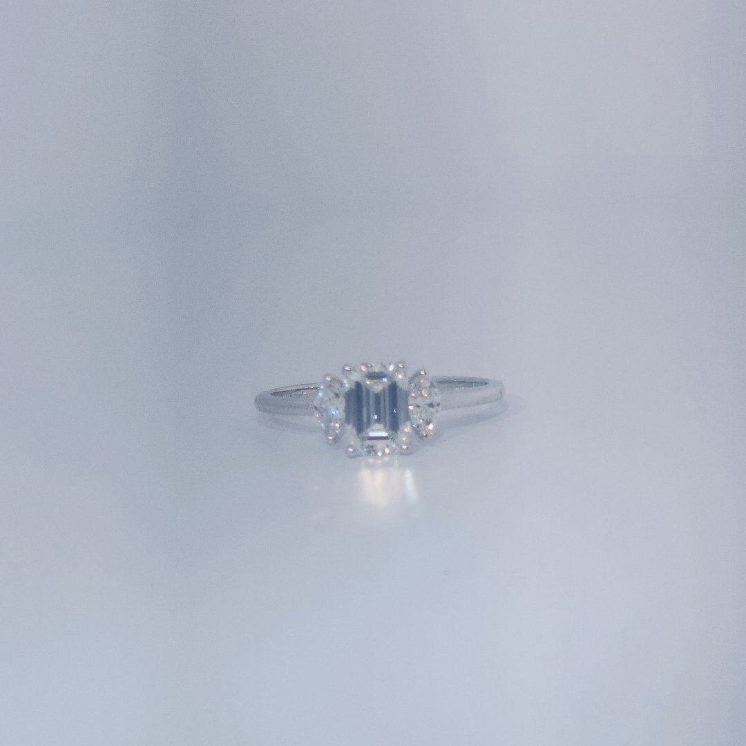 Female Wedding Ring, 14K White Gold, emerald-cut central Diamond (E/VS1, 1.02ct) flanked by 2 round Diamonds (0.25ct total).