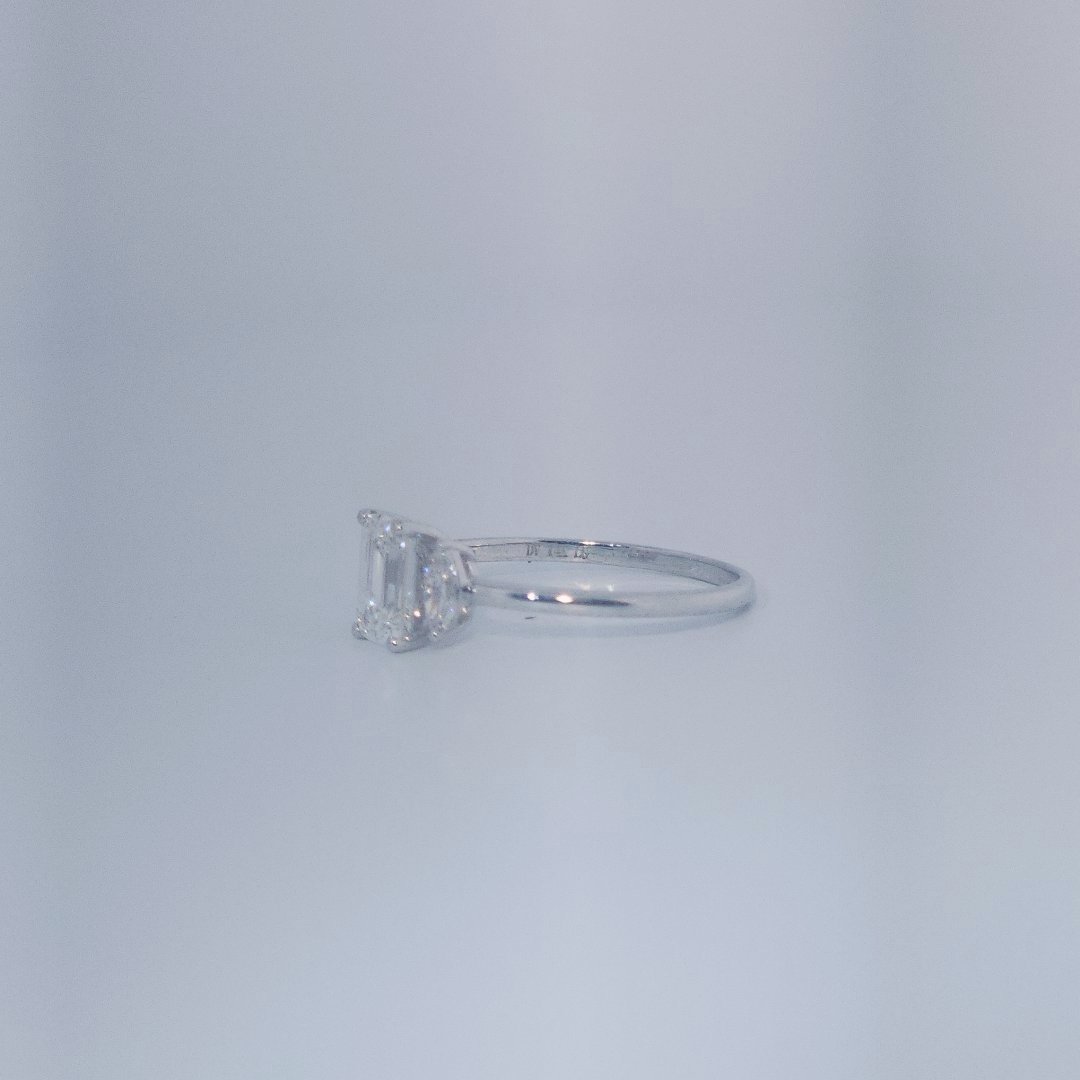 Female Wedding Ring, 14K White Gold, emerald-cut central Diamond (E/VS1, 1.02ct) flanked by 2 round Diamonds (0.25ct total).