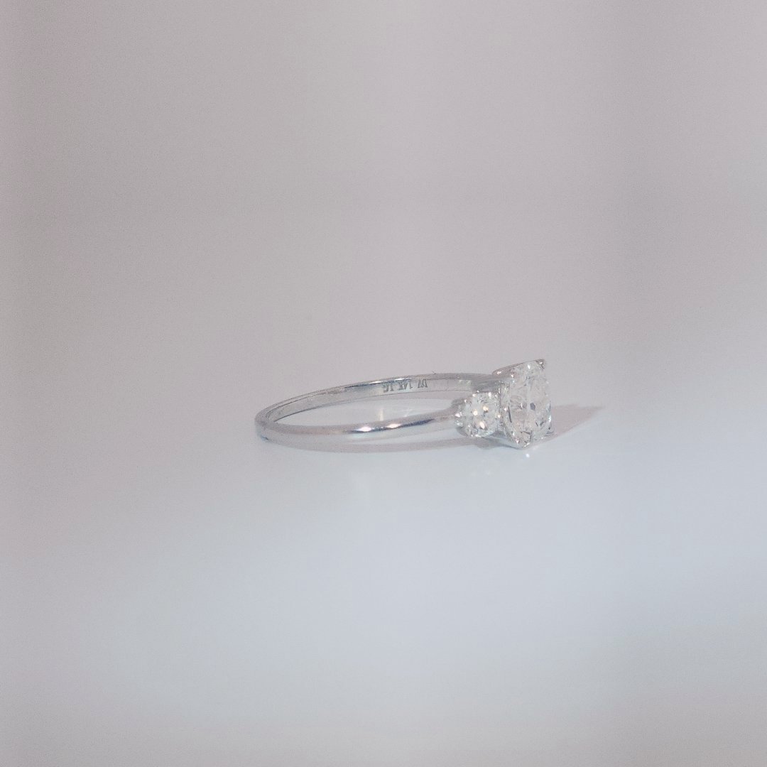 Women's Three-Stone Ring in 14K White Gold featuring a 1.03ct E/VS2 center Diamond flanked by two 0.29ct Diamonds.