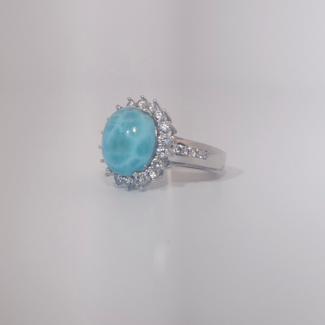 Women's Sterling Silver Ring with oval blue Larimar center stone, accented by round Cubic Zirconia in halo and band setting.