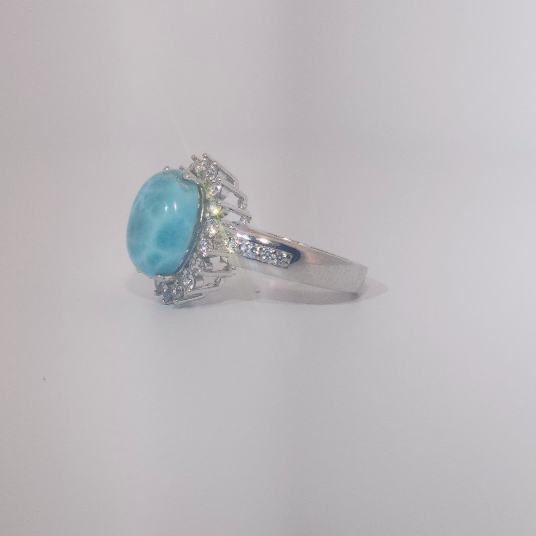 Women's Sterling Silver Ring with oval blue Larimar center stone, accented by round Cubic Zirconia in halo and band setting.