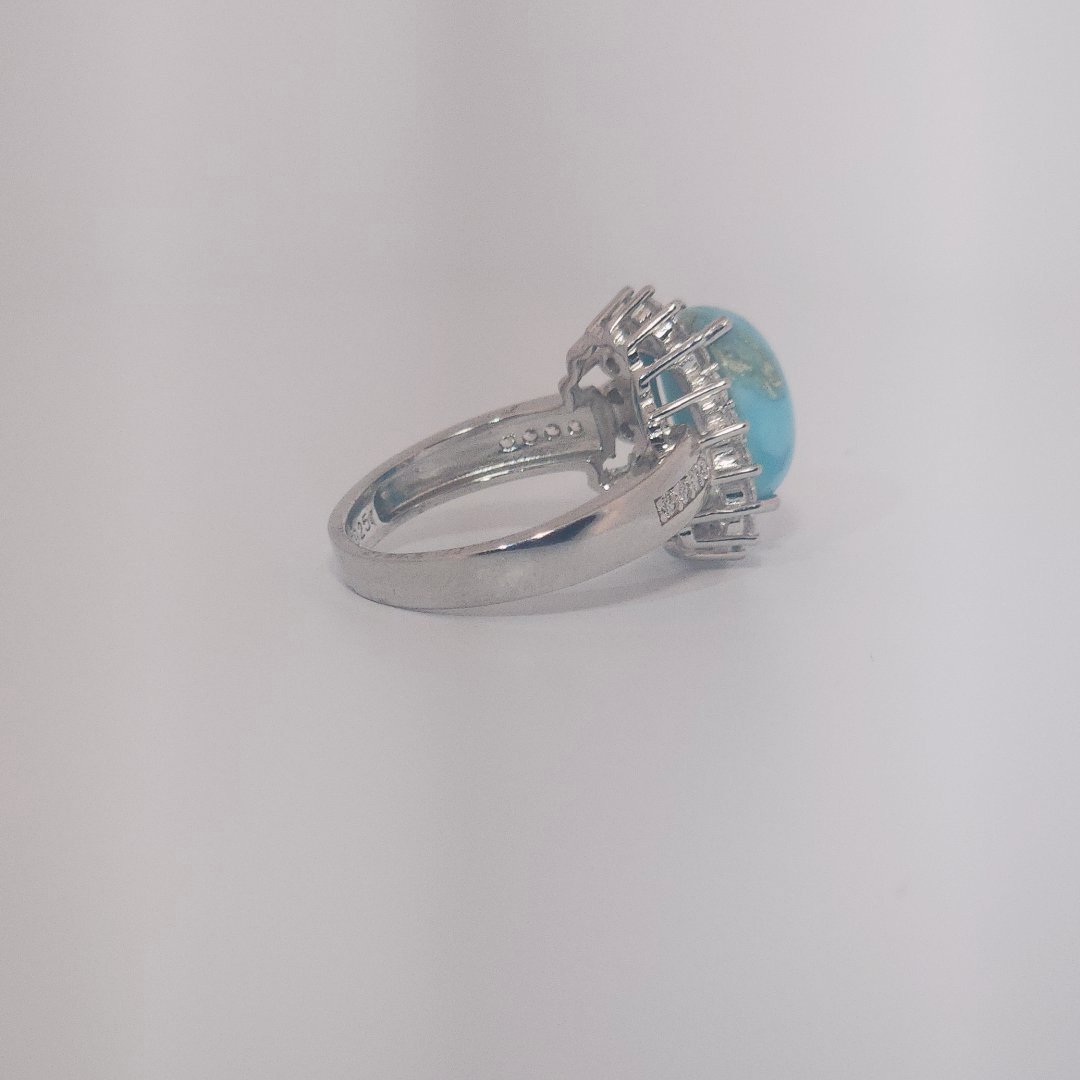 Women's Sterling Silver Ring with oval blue Larimar center stone, accented by round Cubic Zirconia in halo and band setting.