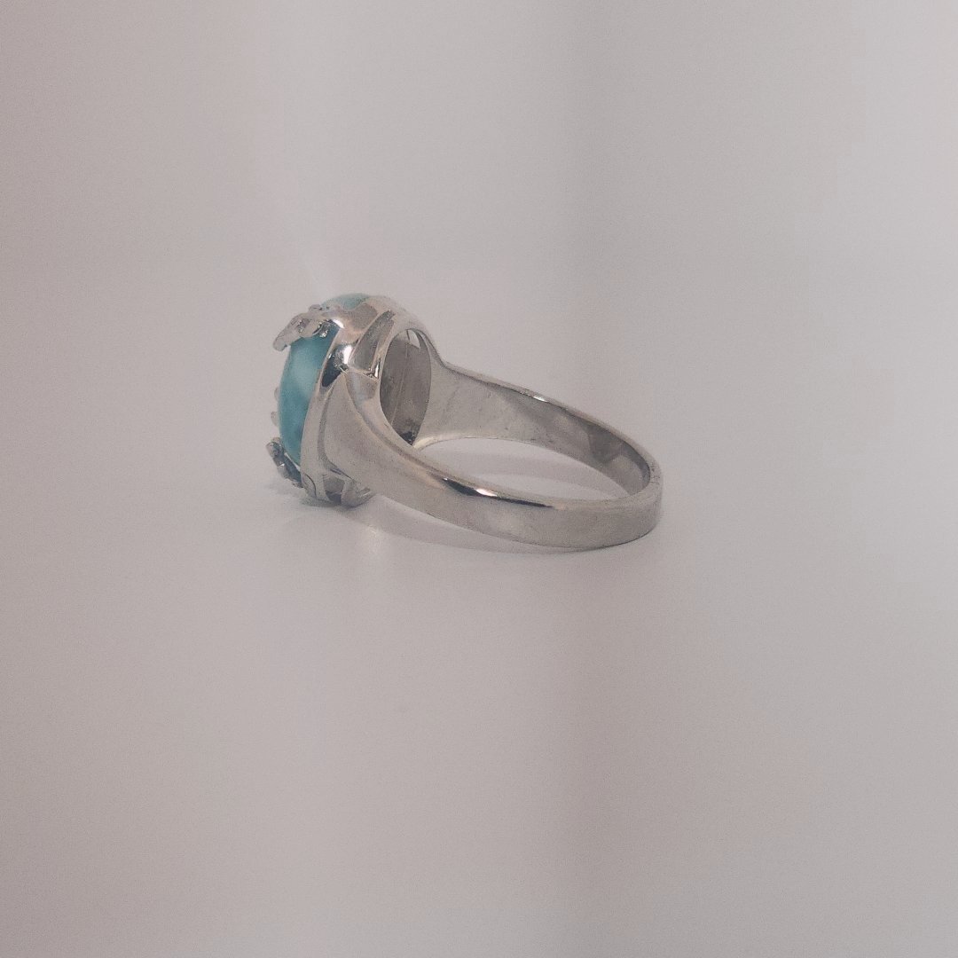 Women’s ring with oval Larimar cabochon in 9 sterling silver featuring a delicate branch motif.