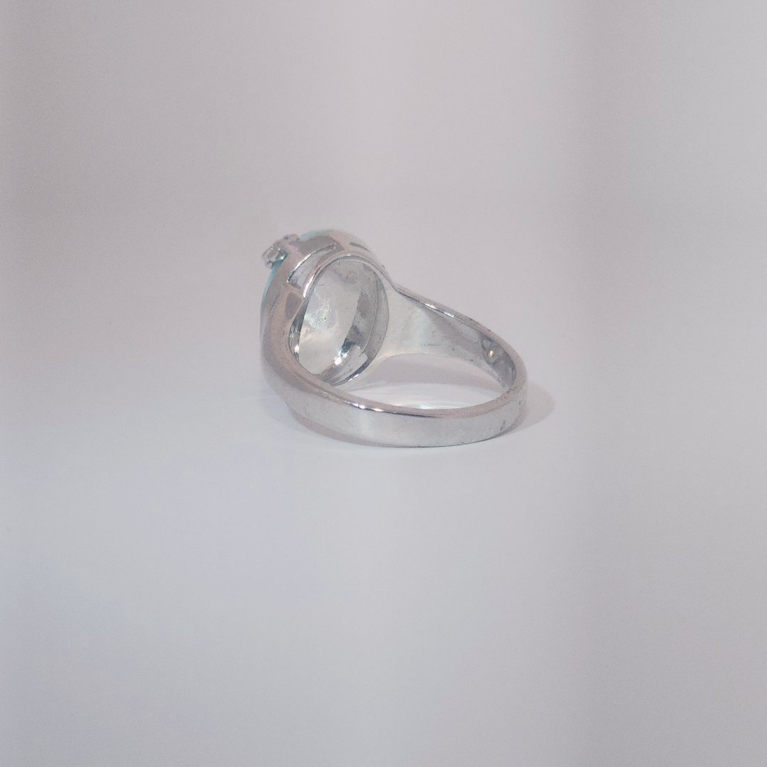 Women’s ring with oval Larimar cabochon in 9 sterling silver featuring a delicate branch motif.