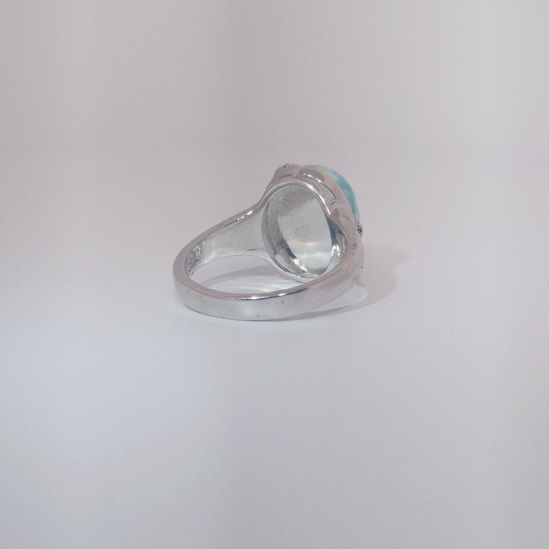 Women’s ring with oval Larimar cabochon in 9 sterling silver featuring a delicate branch motif.