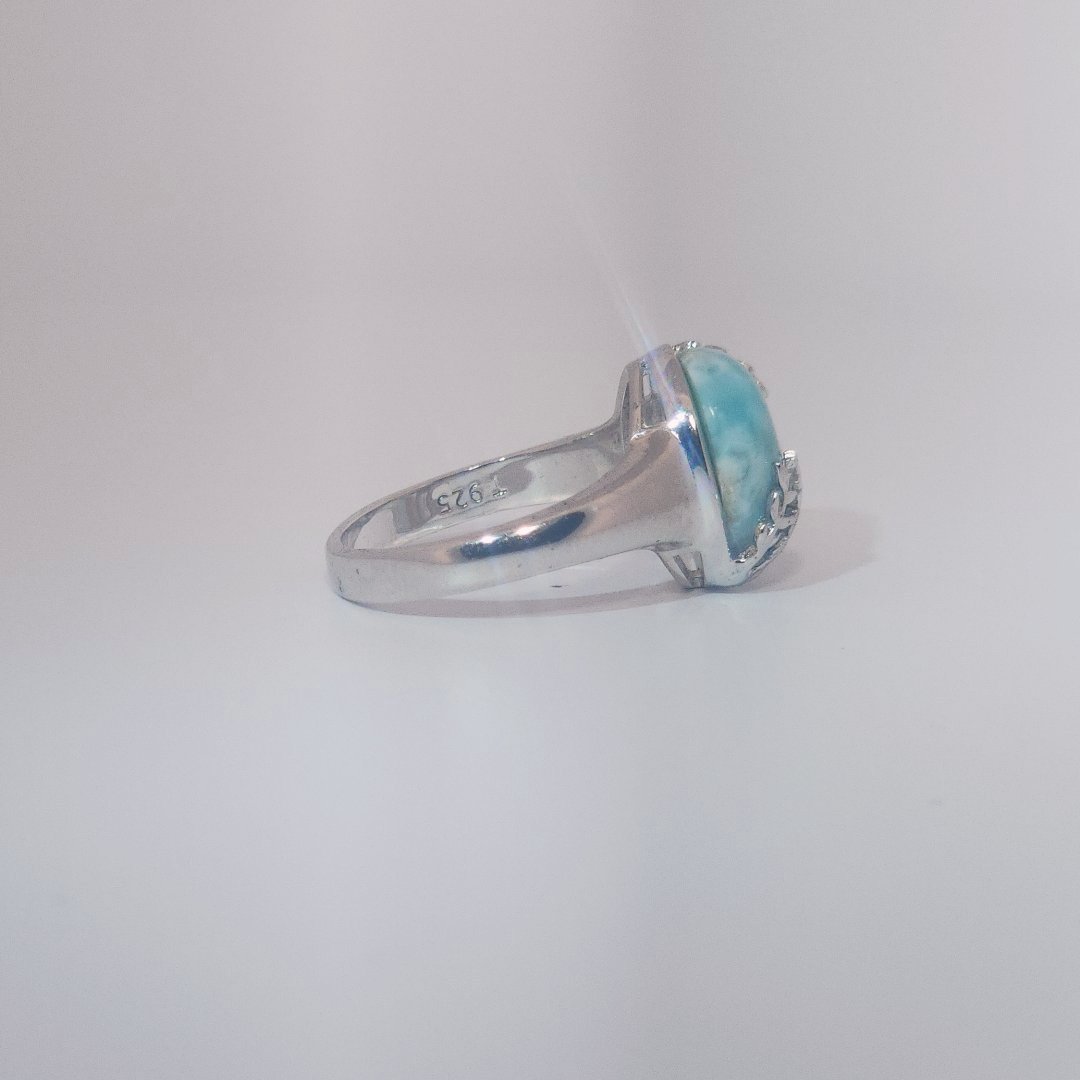 Women’s ring with oval Larimar cabochon in 9 sterling silver featuring a delicate branch motif.