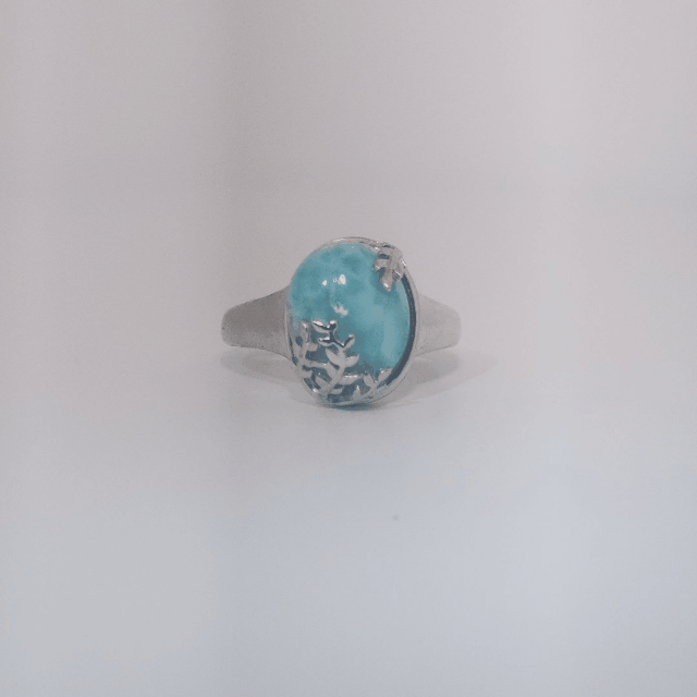 Women’s ring with oval Larimar cabochon in 9 sterling silver featuring a delicate branch motif.