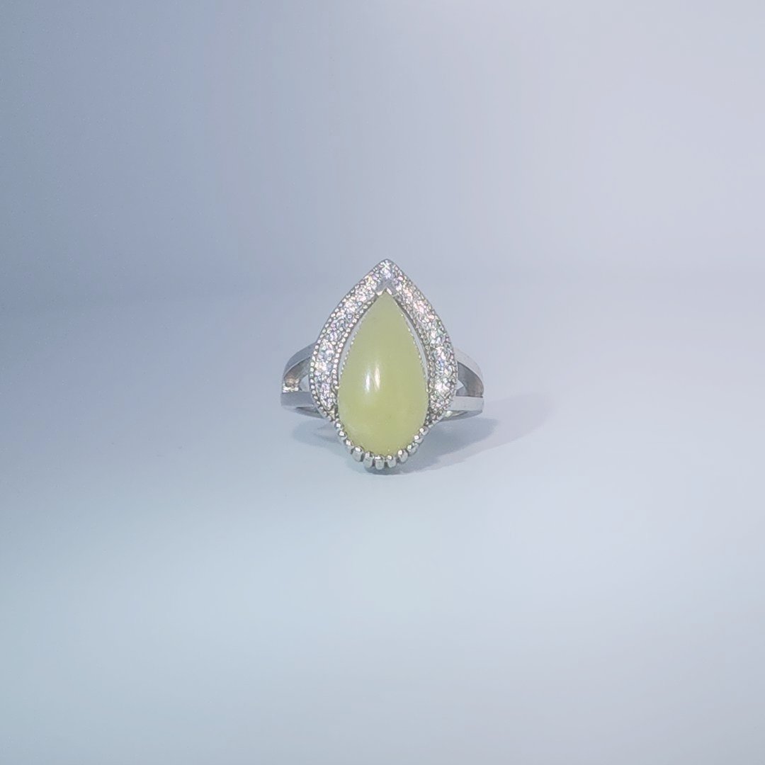 Women's Teardrop Ring in 925 Sterling Silver featuring a pear-shaped yellow-green Jade center stone accentuated by a delicate halo of small, bright stones.