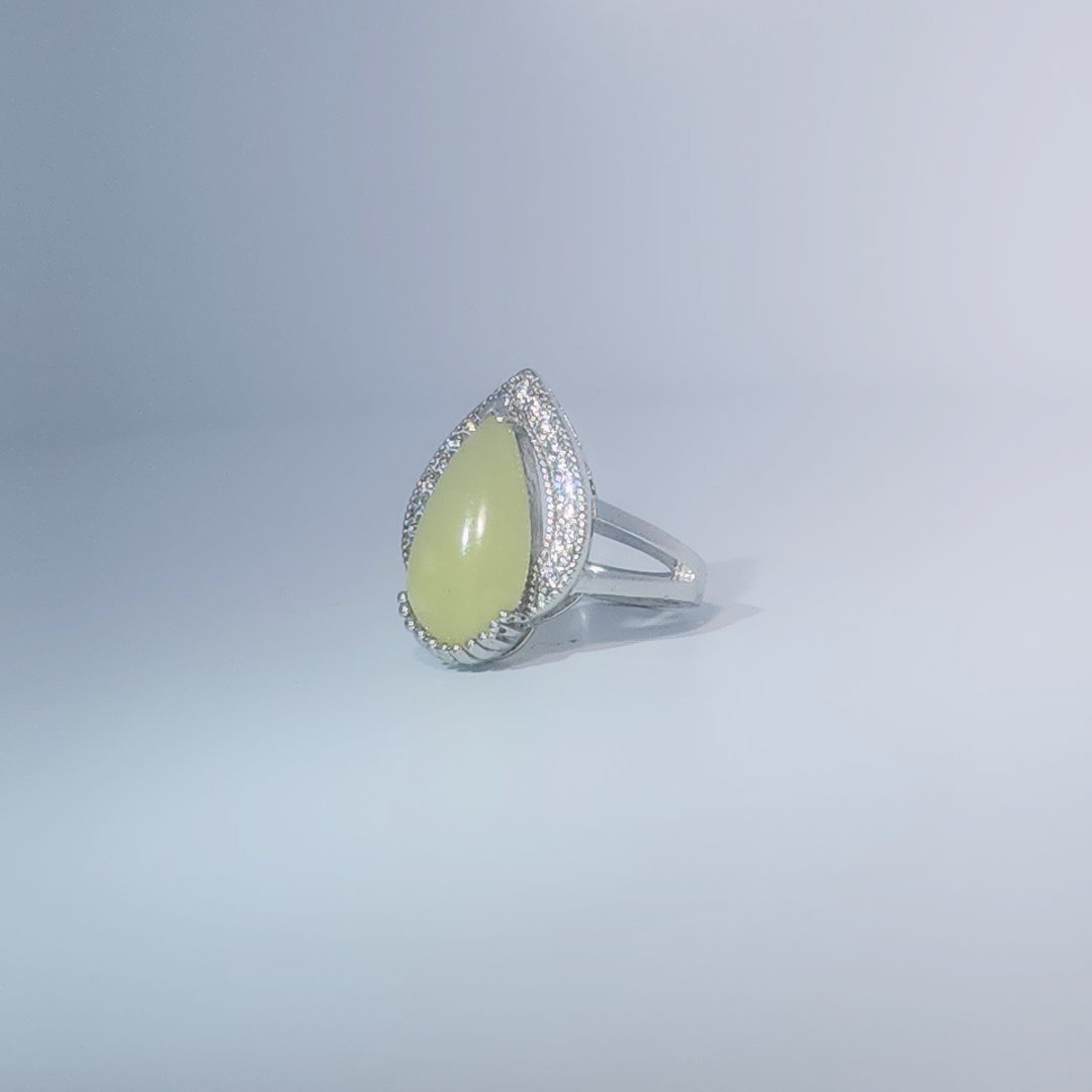 Women's Teardrop Ring in 925 Sterling Silver featuring a pear-shaped yellow-green Jade center stone accentuated by a delicate halo of small, bright stones.