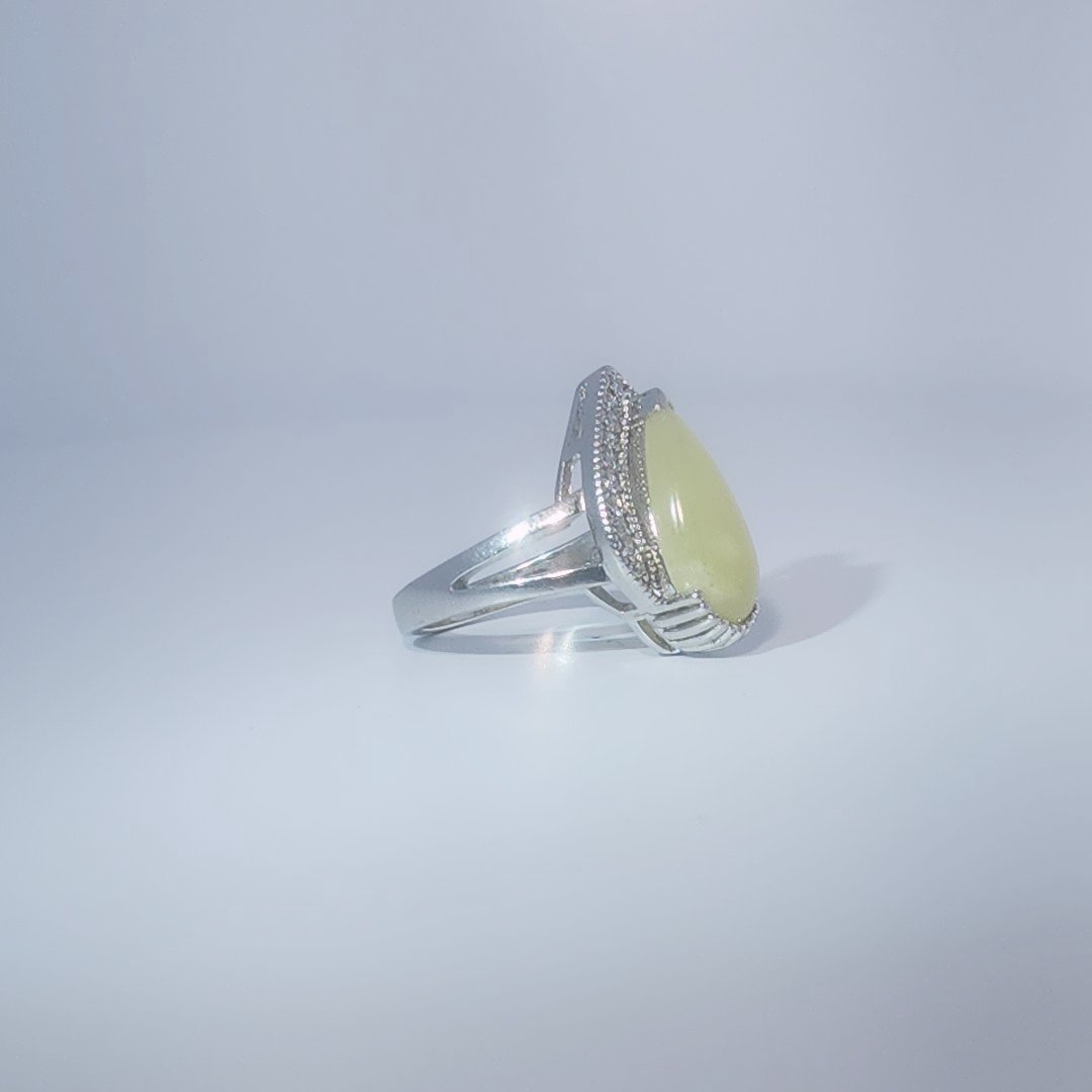 Women's Teardrop Ring in 925 Sterling Silver featuring a pear-shaped yellow-green Jade center stone accentuated by a delicate halo of small, bright stones.