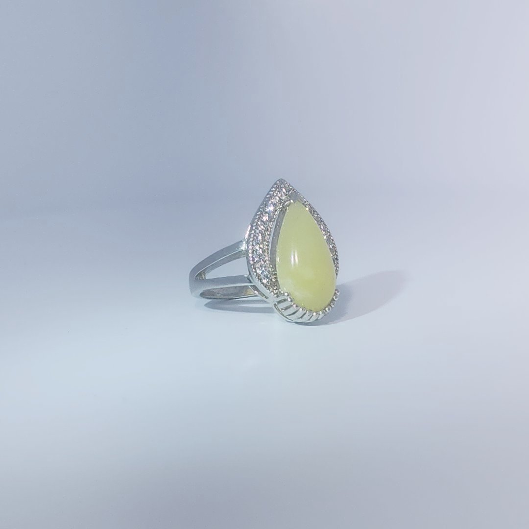 Women's Teardrop Ring in 925 Sterling Silver featuring a pear-shaped yellow-green Jade center stone accentuated by a delicate halo of small, bright stones.