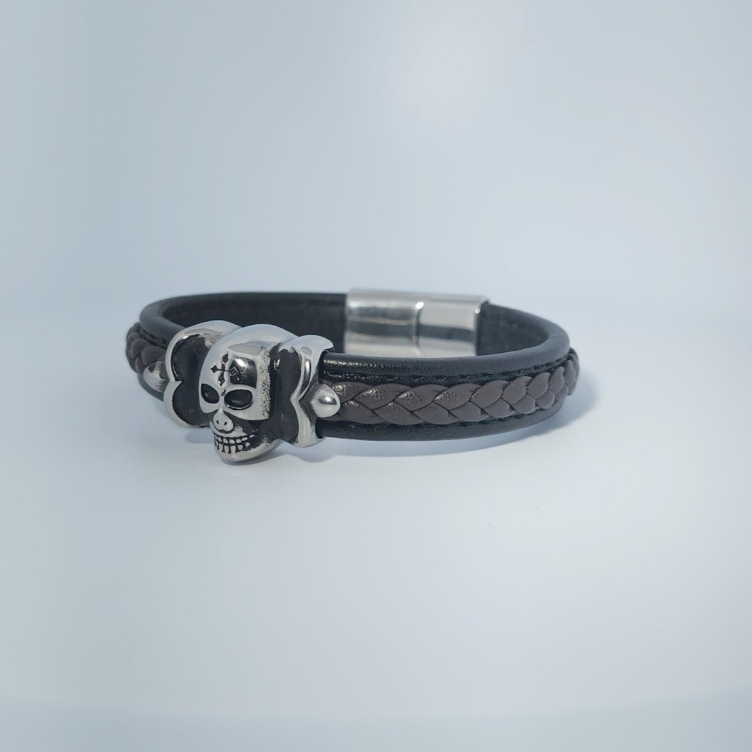 Bracelet for men in stainless steel and braided leather with skull design centerpiece and magnetic clasp.