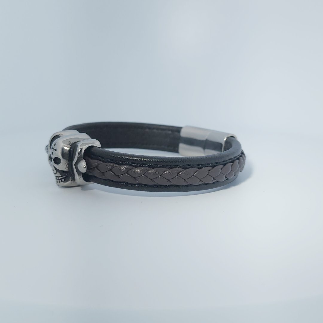 Bracelet for men in stainless steel and braided leather with skull design centerpiece and magnetic clasp.