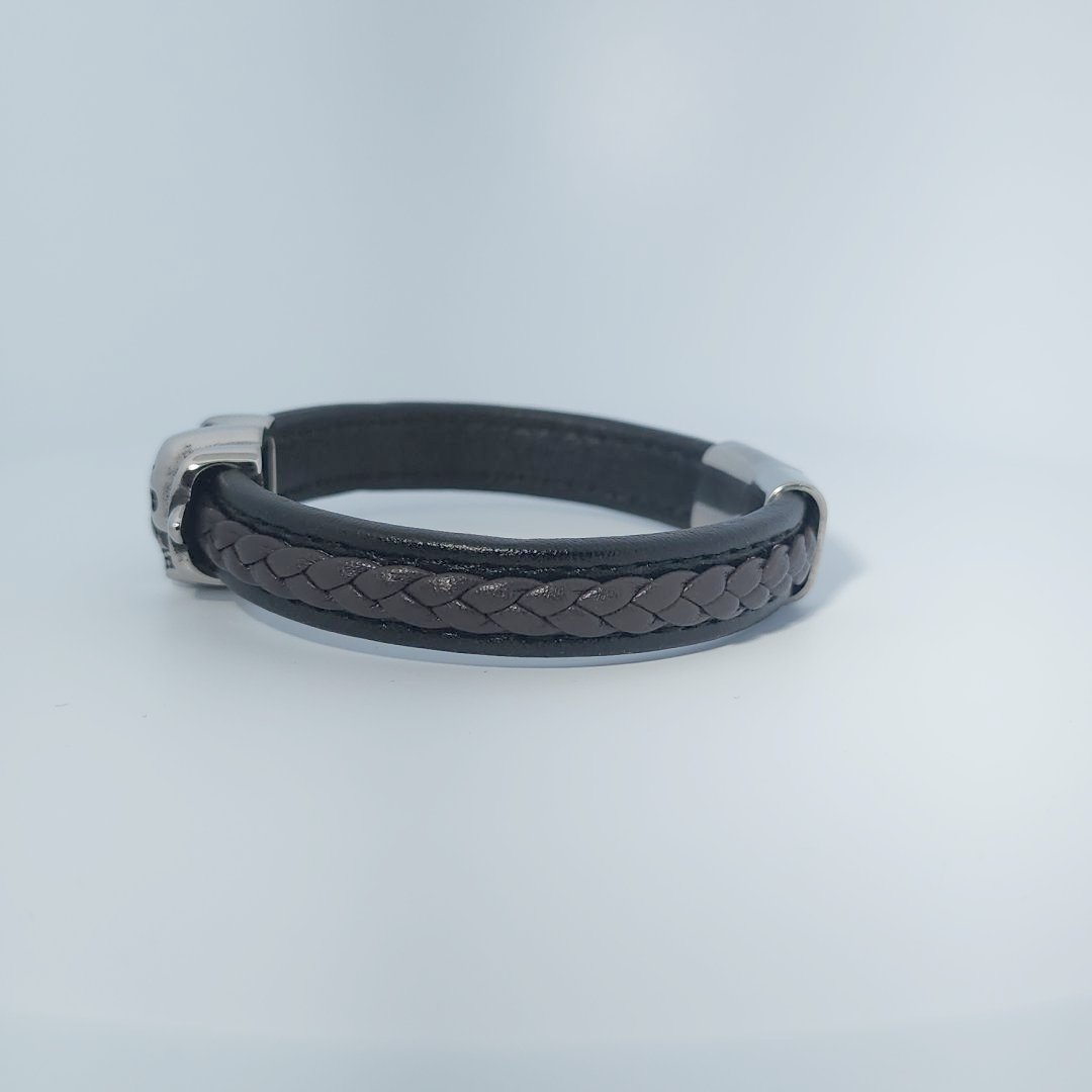 Bracelet for men in stainless steel and braided leather with skull design centerpiece and magnetic clasp.