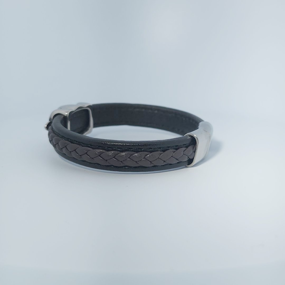 Bracelet for men in stainless steel and braided leather with skull design centerpiece and magnetic clasp.