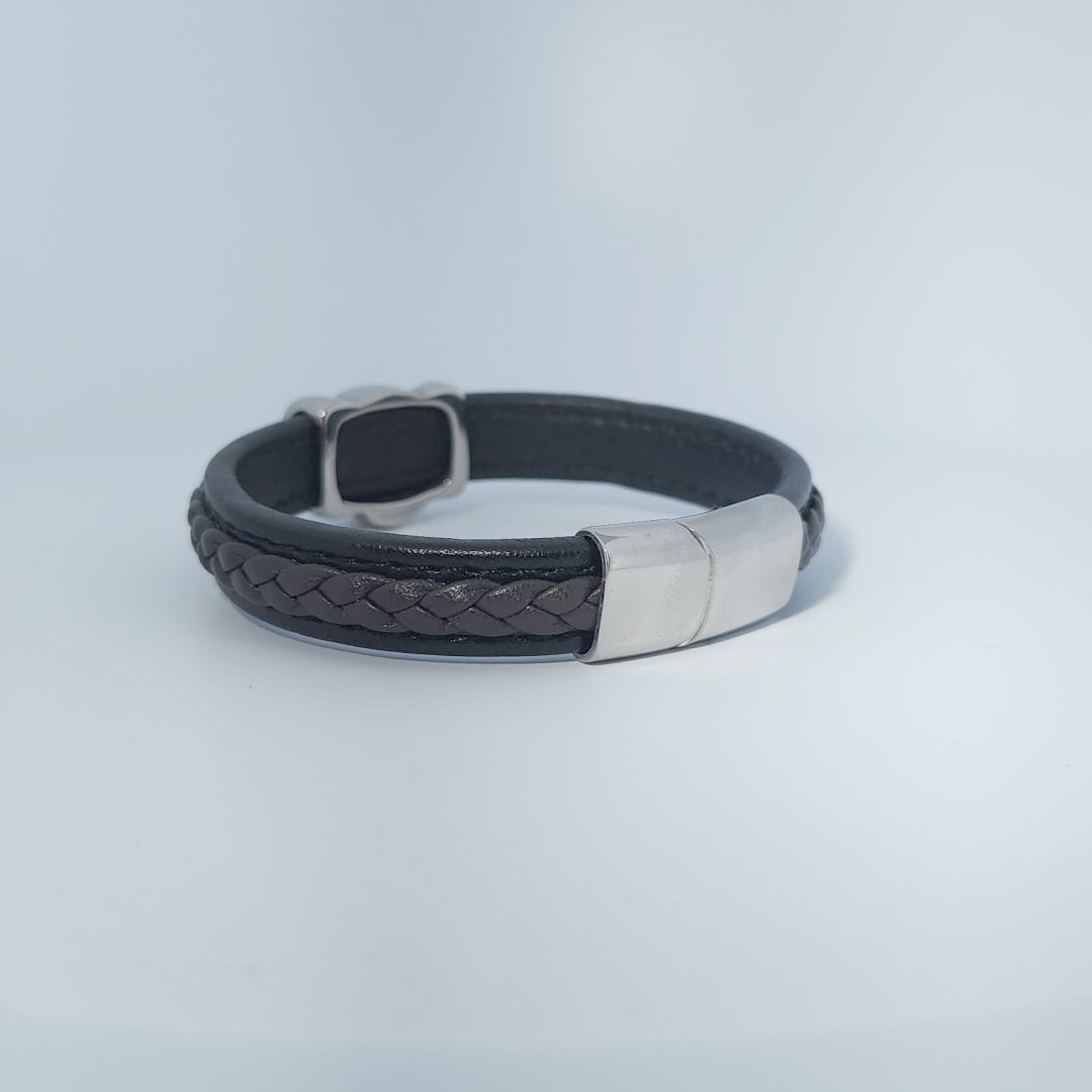 Bracelet for men in stainless steel and braided leather with skull design centerpiece and magnetic clasp.