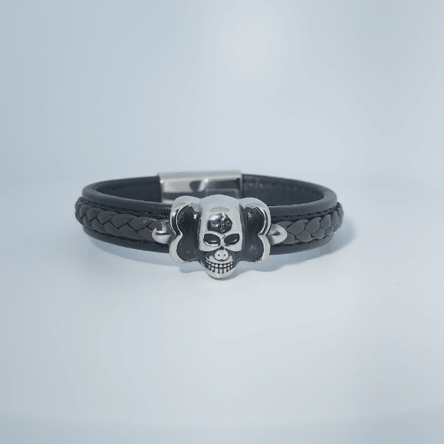Bracelet for men in stainless steel and braided leather with skull design centerpiece and magnetic clasp.