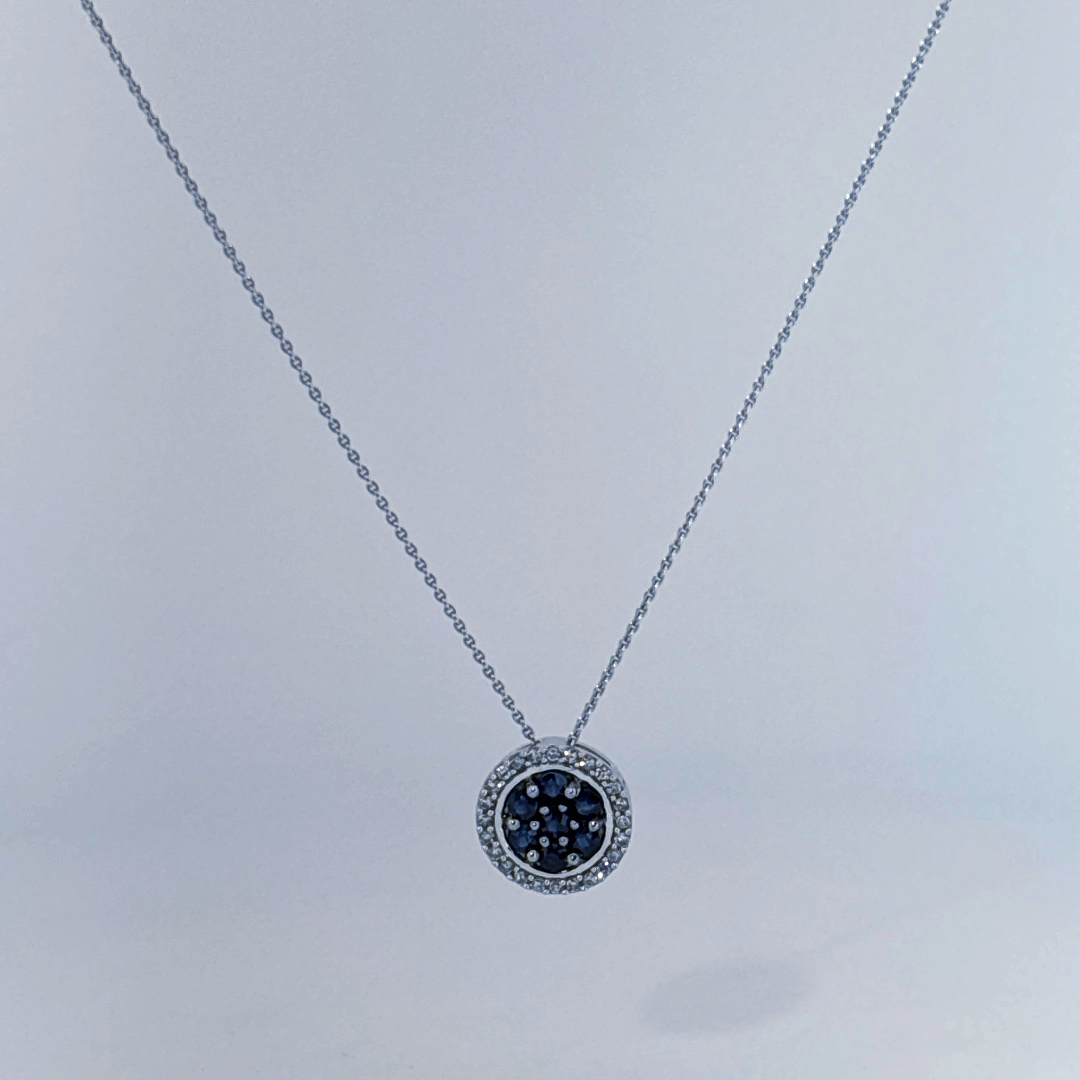 14K White Gold Necklace, set with 7 Blue Sapphires in a circular pendant surrounded by smaller clear stones.