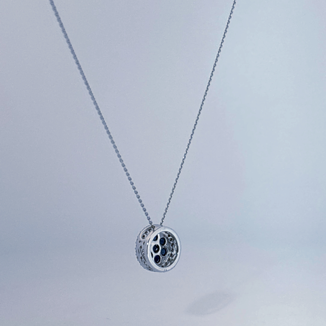 14K White Gold Necklace, set with 7 Blue Sapphires in a circular pendant surrounded by smaller clear stones.