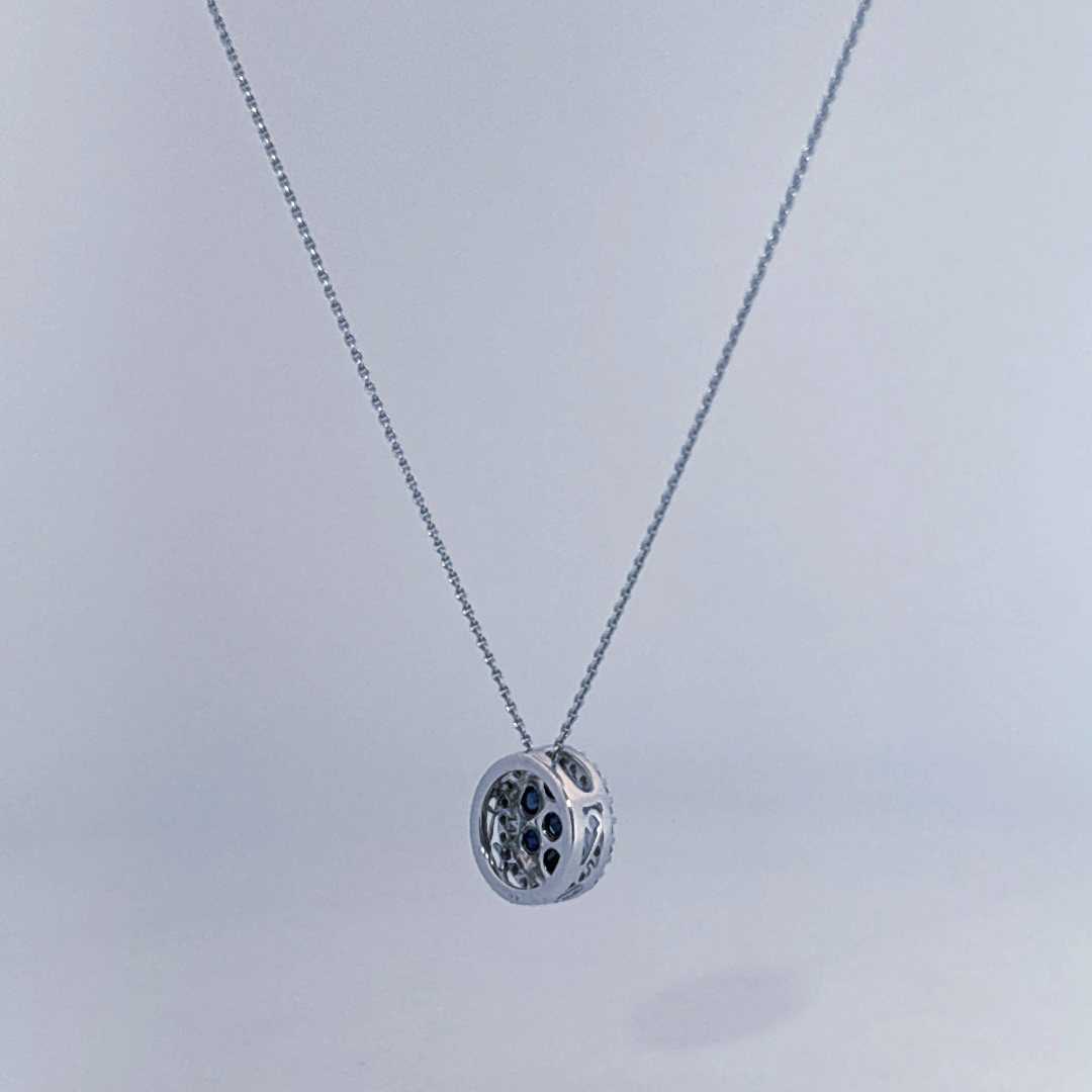 14K White Gold Necklace, set with 7 Blue Sapphires in a circular pendant surrounded by smaller clear stones.