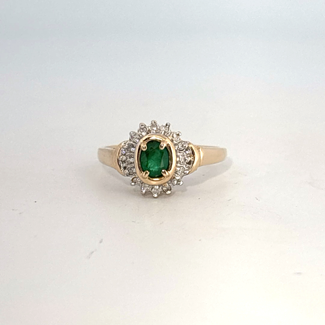 14K Yellow Gold Ring, set with 1 Oval Emerald and surrounding Round Diamonds, women's style.