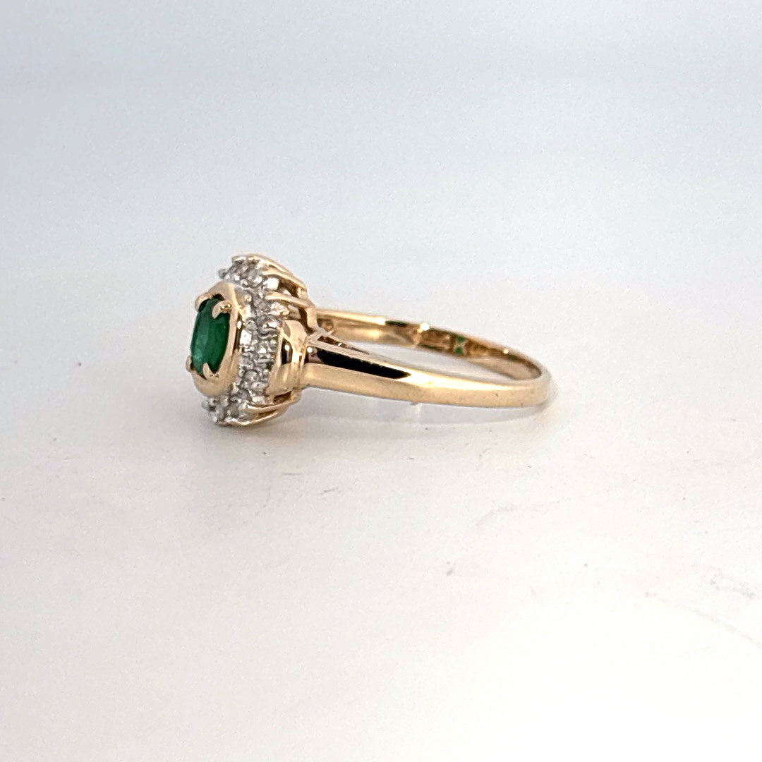 14K Yellow Gold Ring, set with 1 Oval Emerald and surrounding Round Diamonds, women's style.