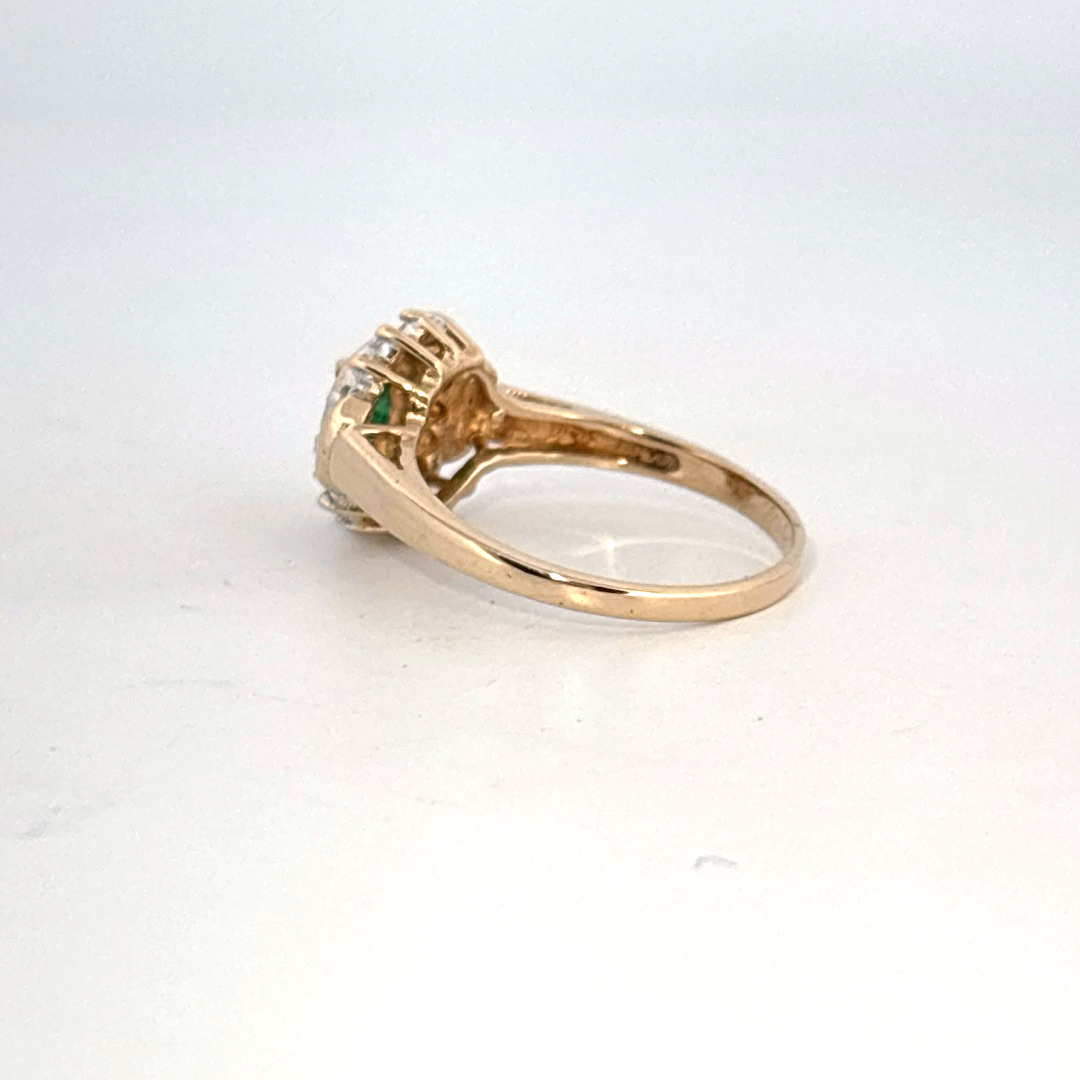 14K Yellow Gold Ring, set with 1 Oval Emerald and surrounding Round Diamonds, women's style.