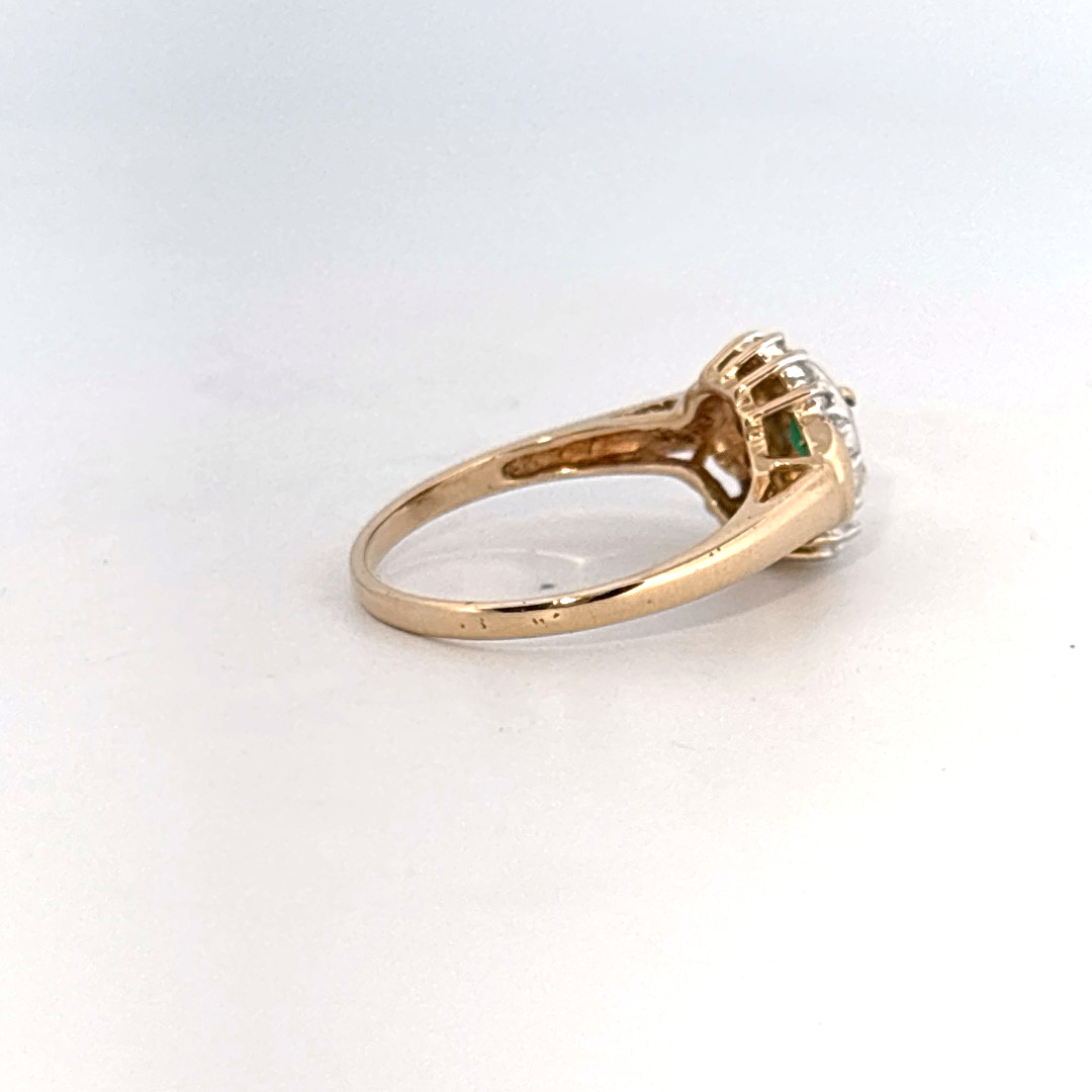 14K Yellow Gold Ring, set with 1 Oval Emerald and surrounding Round Diamonds, women's style.