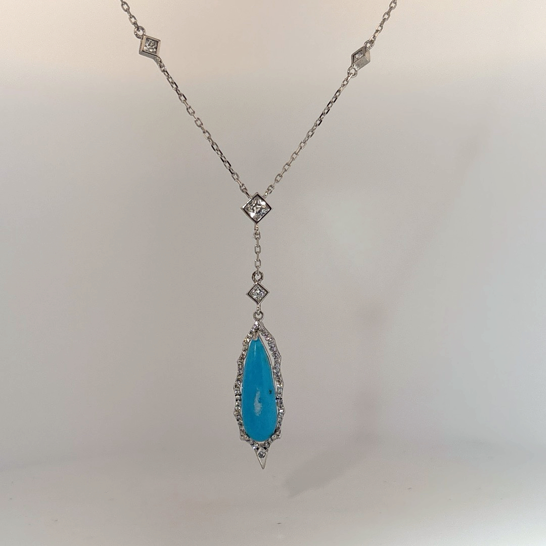 Sterling Silver Necklace set with 1 Turquoise stone and multiple small clear stones.