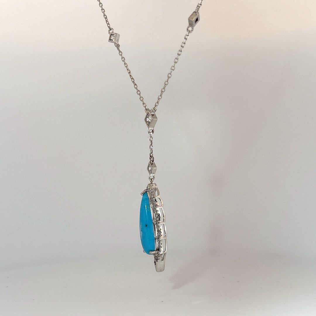 Sterling Silver Necklace set with 1 Turquoise stone and multiple small clear stones.