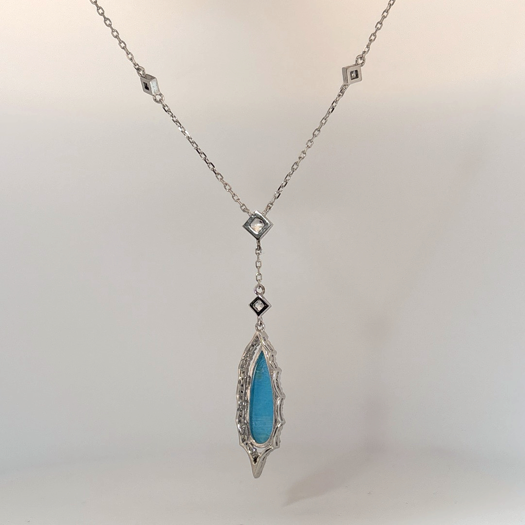 Sterling Silver Necklace set with 1 Turquoise stone and multiple small clear stones.