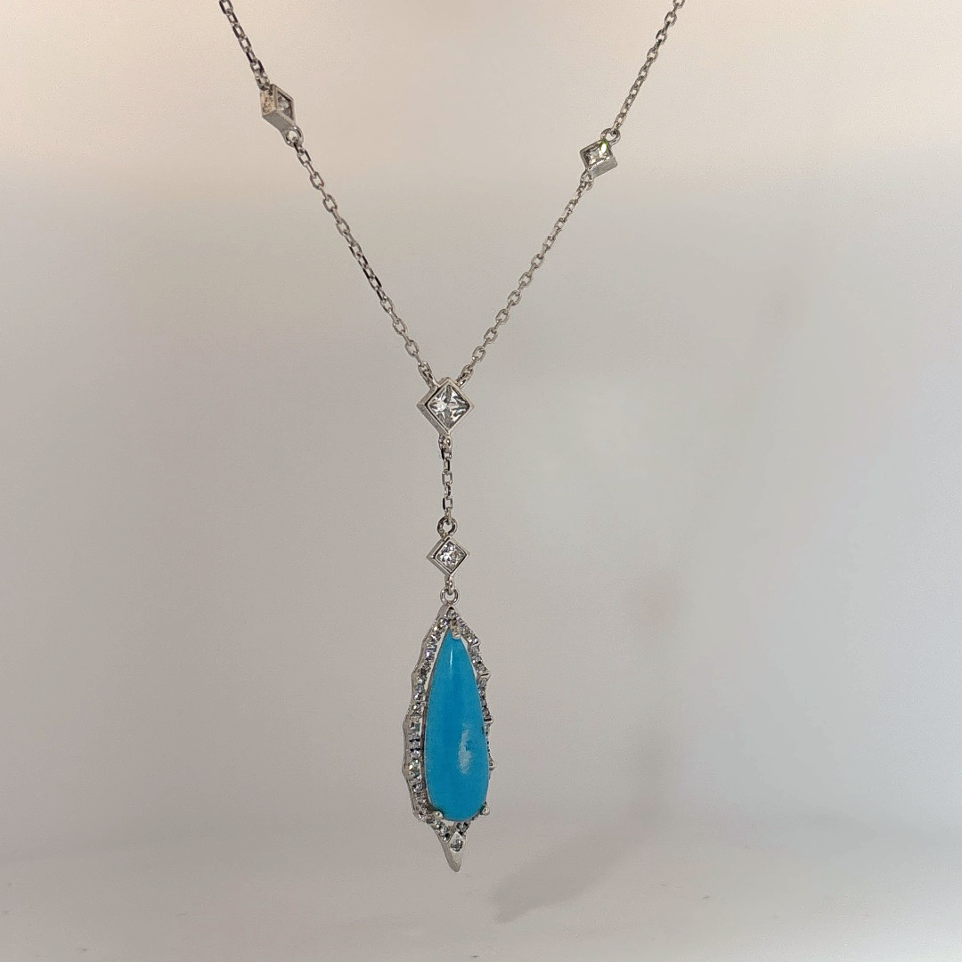 Sterling Silver Necklace set with 1 Turquoise stone and multiple small clear stones.