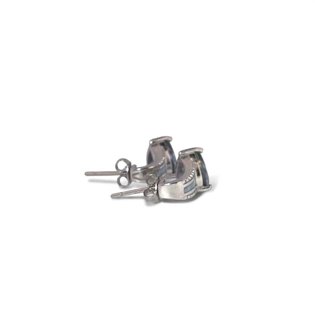 Sterling Silver 925 Rhodium Plated Earrings, set with 2 Trillion Mystic Topaz stones, accented with clear stones and white inlay detailing.
