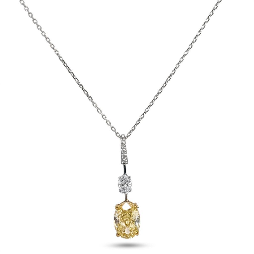 18K White/Yellow Gold Pendant, set with 1 Oval Fancy Yellow Lab Grown Diamond (2.1ct, VS1), 1 Oval Colorless Lab Grown Diamond (0.5ct, VVS1), and 6 Round Near Colorless Lab Grown Diamonds (0.06ct total, VS1).