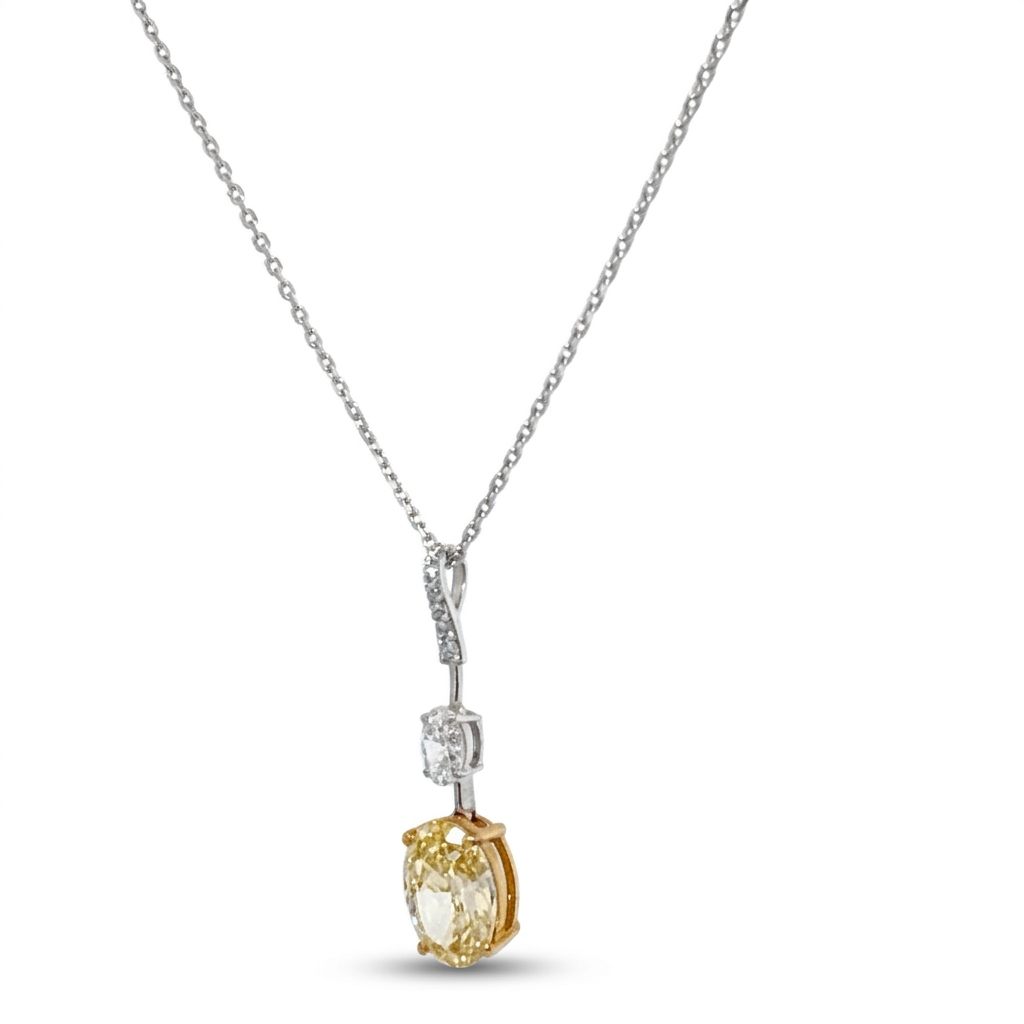 18K White/Yellow Gold Pendant, set with 1 Oval Fancy Yellow Lab Grown Diamond (2.1ct, VS1), 1 Oval Colorless Lab Grown Diamond (0.5ct, VVS1), and 6 Round Near Colorless Lab Grown Diamonds (0.06ct total, VS1).