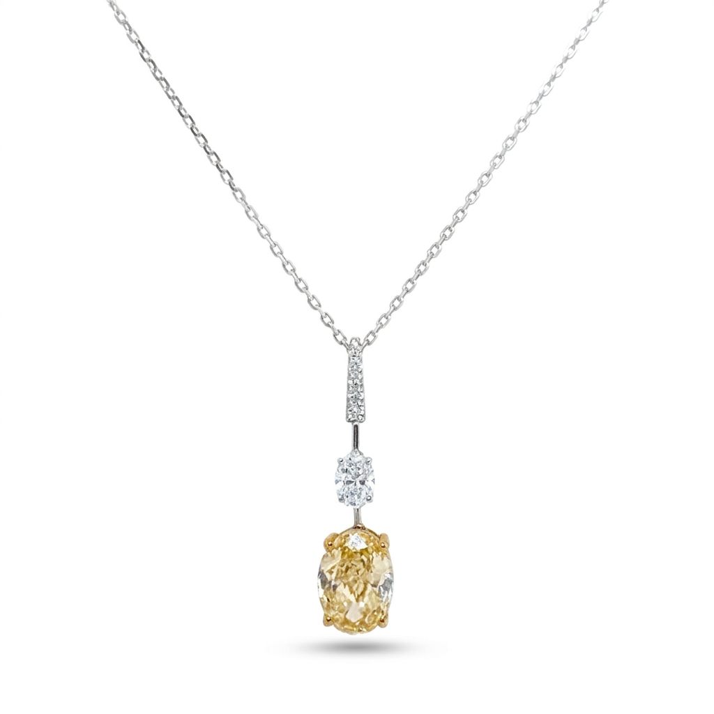 18K White/Yellow Gold Pendant, set with 1 Oval Fancy Yellow Lab Grown Diamond (2.1ct, VS1), 1 Oval Colorless Lab Grown Diamond (0.5ct, VVS1), and 6 Round Near Colorless Lab Grown Diamonds (0.06ct total, VS1).