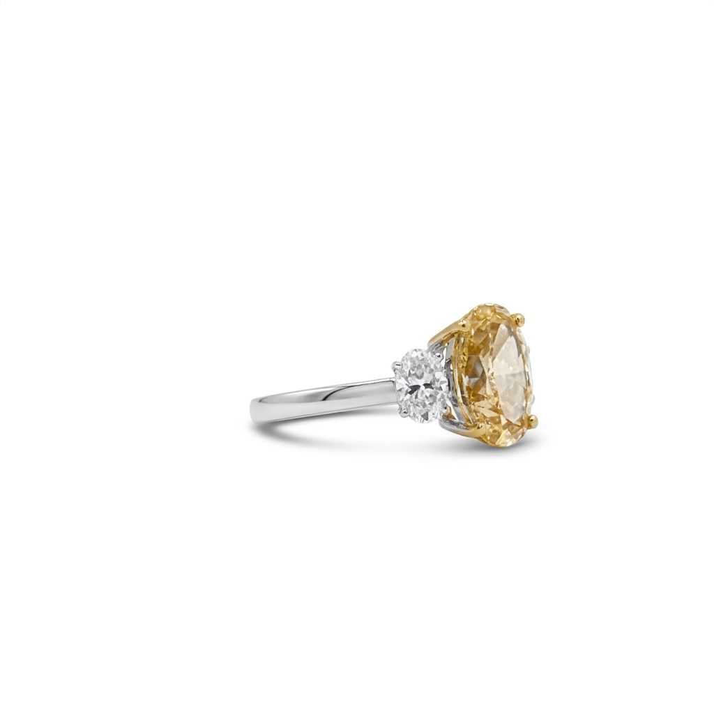 18K Dual White/Yellow Gold Ring, set with 1 Oval Fancy Intense Yellow Lab Grown Diamond (2.51ct, VS1) and 2 Oval D Colorless Lab Grown Diamonds (0.64ct total, VVS1), 3.1g.